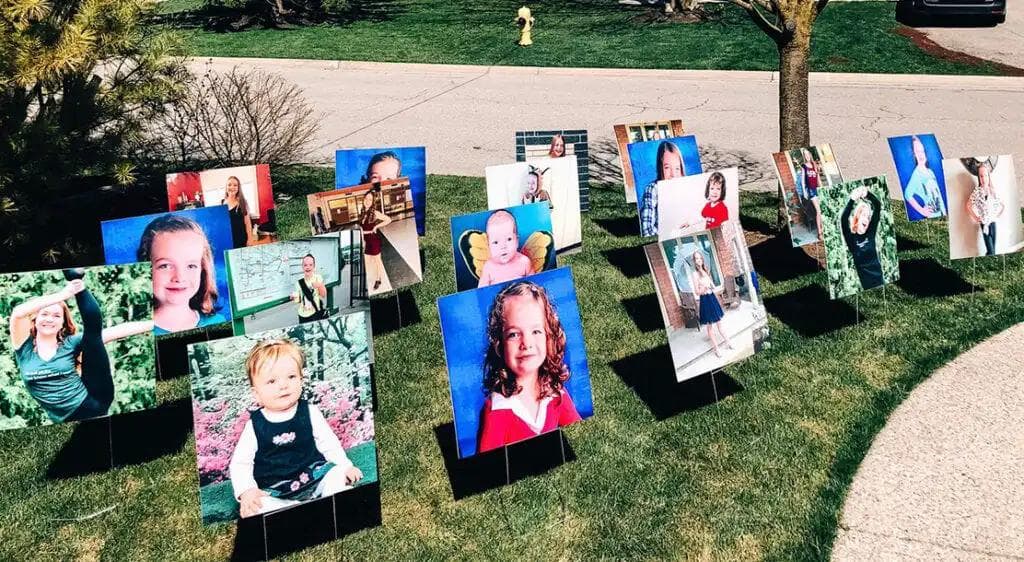 Lawn front signs of graduating students as toddlers