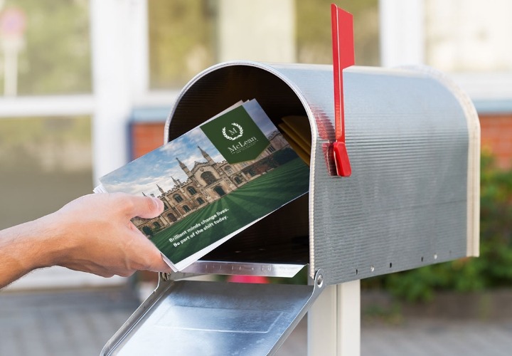 Placing a university postcard into a mailbox