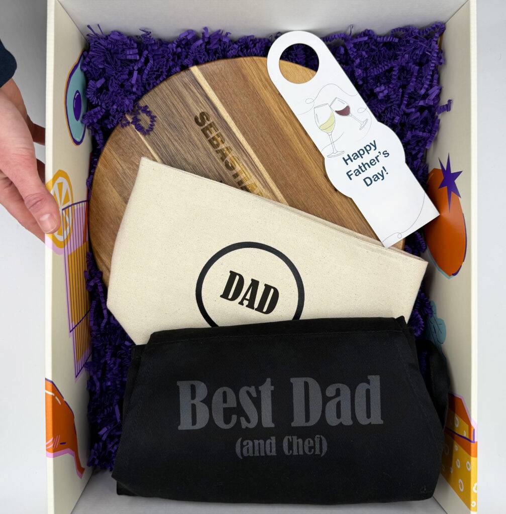 Custom box with engraved cutting board, cooking apron, and personalized gifts.